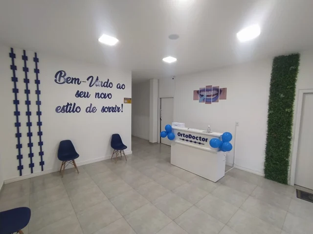 Recepção da clínica Ortodoctor, com balcão branco e decoração azul